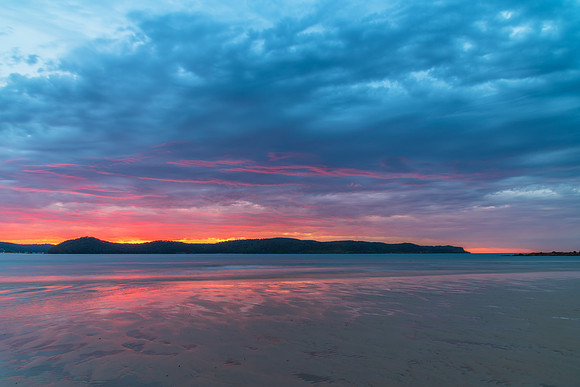 Colourful cloud filled sunrise at the seaside