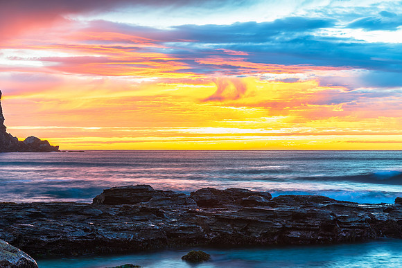 Winter sunrise by the sea shore with rain clouds