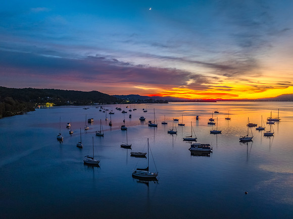 Aerial sunrise waterscape with boats and high cloud