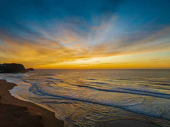 Sunrise and high cloud cover by the sea and lagoon