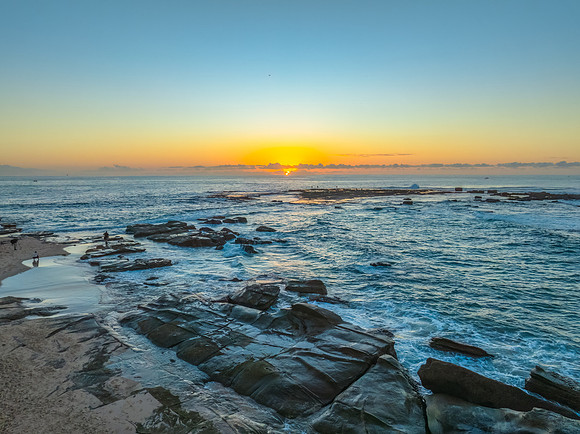 Sunrise over the sea and rocks with clear skies