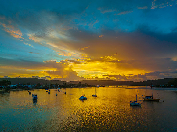 Aerial sunrise waterscape with boats, colour and clouds