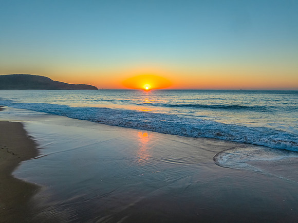 Sunrise seascape with clear skies and orange horizon