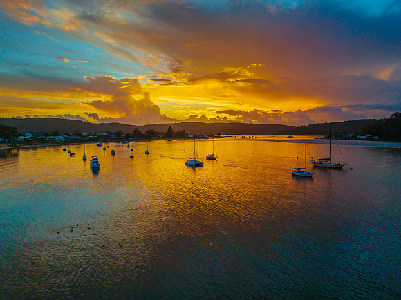 Aerial sunrise waterscape with boats, colour and clouds