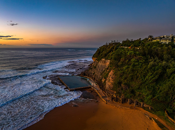 Sunrise at the beach with waves and a smattering of clouds