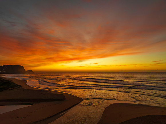 Sunrise and high cloud cover by the sea and lagoon