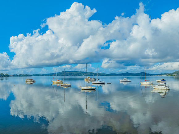 Aerial views over the bay with clouds, reflections and boats