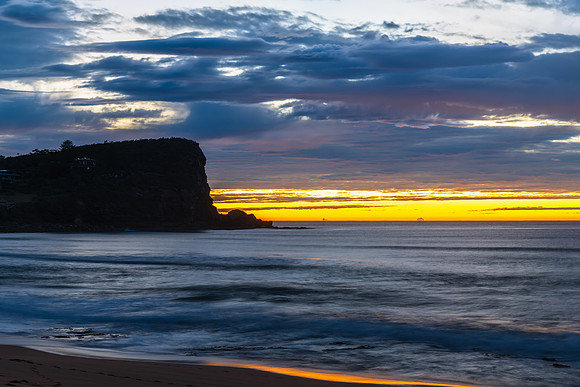 Winter sunrise by the sea shore with rain clouds