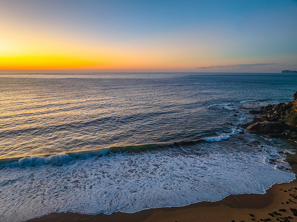 Sunrise seascape with clear skies and orange horizon