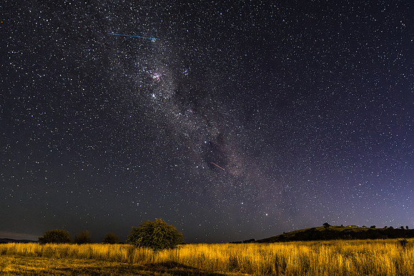 The night sky and Milky Way Galaxy with satellites