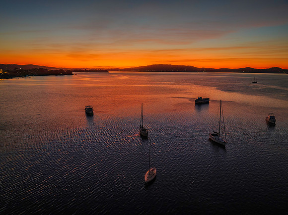 Aerial sunrise waterscape with boats and high cloud