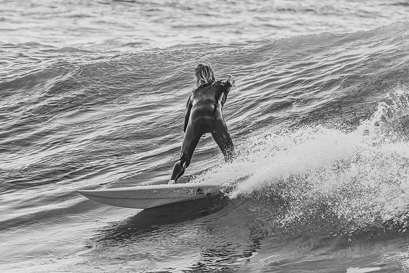 Surfer catching a wave in monochrome