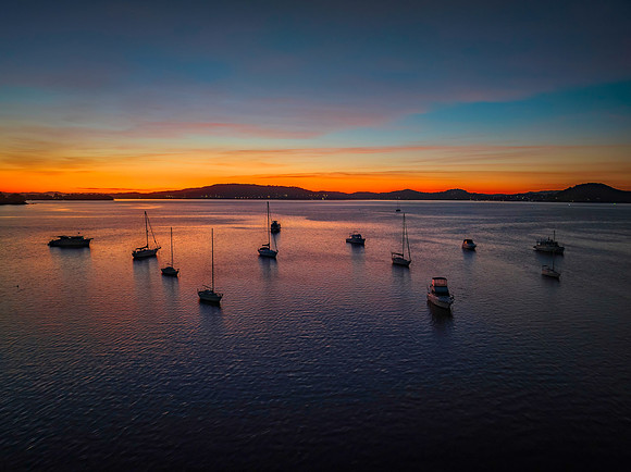Aerial sunrise waterscape with boats and high cloud