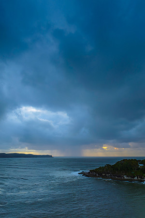 Sunrise seascape with overcast sky and rain clouds