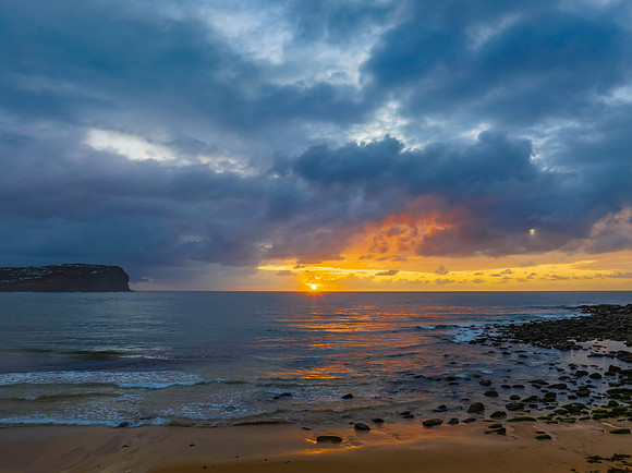 Drizzly moody sunrise seascape with cloud filled sky