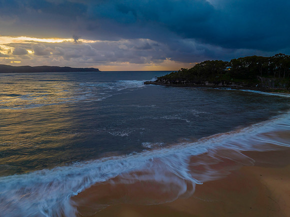 Sunrise seascape with overcast sky and rain clouds