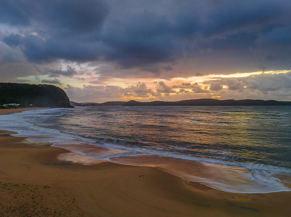 Sunrise seascape with overcast sky and rain clouds