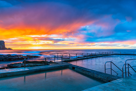 Winter sunrise by the sea pool with rain clouds