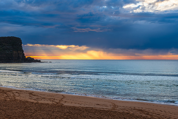 Winter sunrise by the sea shore with rain clouds