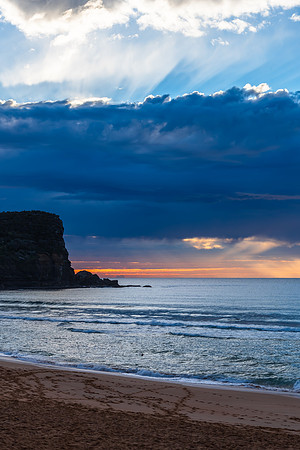 Winter sunrise by the sea shore with rain clouds