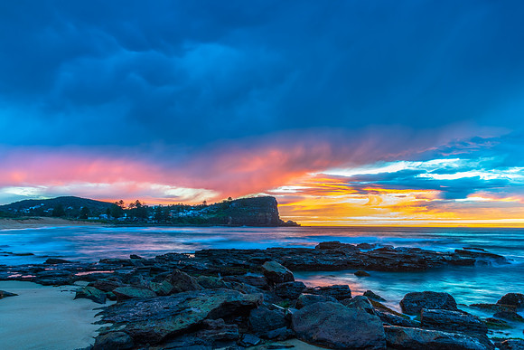 Winter sunrise by the sea shore with rain clouds