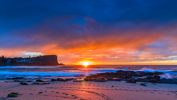 Winter sunrise by the sea shore with rain clouds