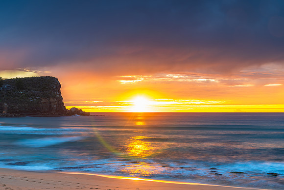 Winter sunrise by the sea shore with rain clouds