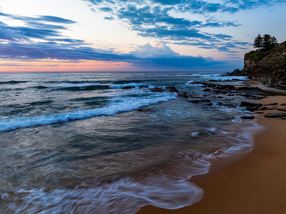 Seaside Sunrise Under a Cloud-Filled Sky