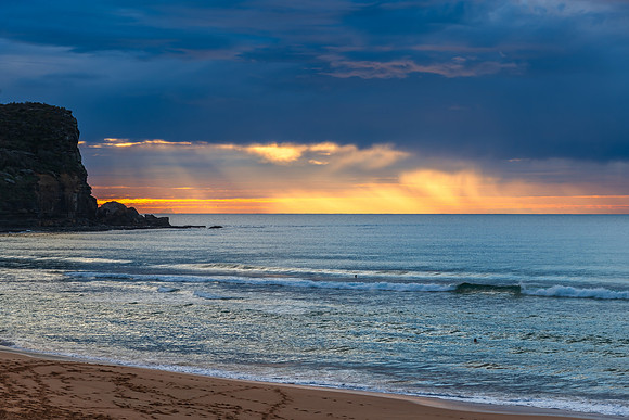 Winter sunrise by the sea shore with rain clouds