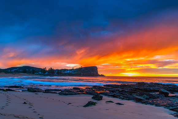 Winter sunrise by the sea shore with rain clouds