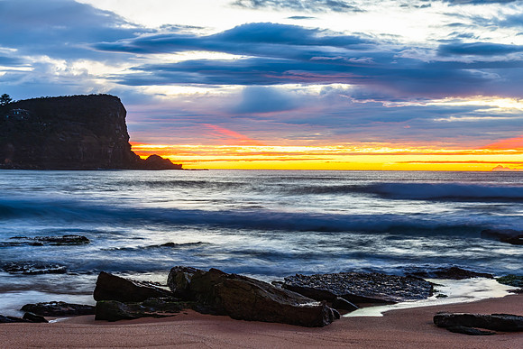Winter sunrise by the sea shore with rain clouds