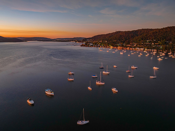 Aerial sunrise waterscape with boats and high cloud