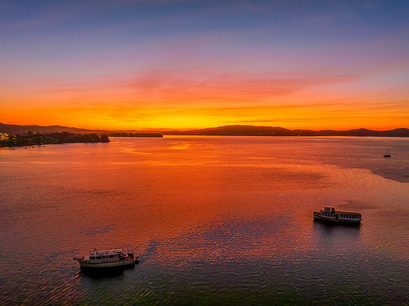 Aerial sunrise waterscape with boats and high cloud