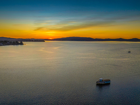 Aerial sunrise waterscape with boats and high cloud