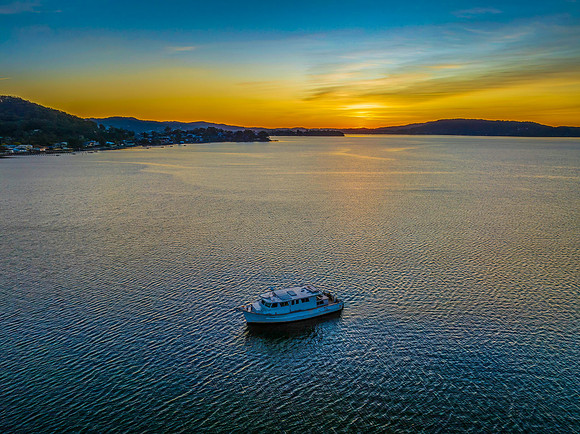Aerial sunrise waterscape with boats and high cloud