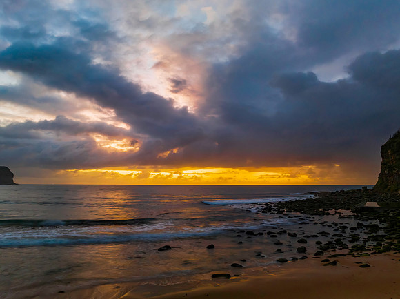 Drizzly moody sunrise seascape with cloud filled sky