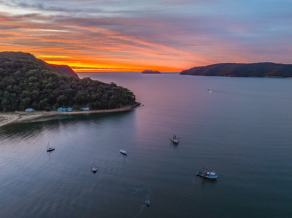 Sunrise over the bay with boats and cloud covered sky