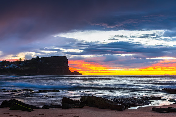 Winter sunrise by the sea shore with rain clouds
