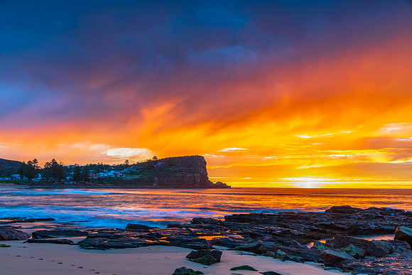 Winter sunrise by the sea shore with rain clouds