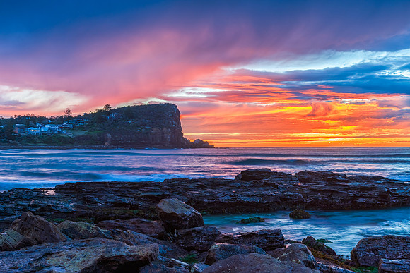 Winter sunrise by the sea shore with rain clouds