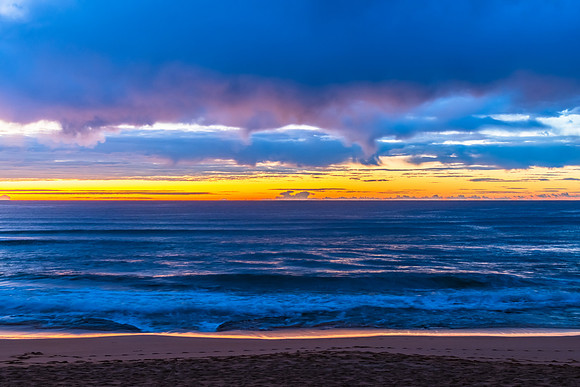 Winter sunrise by the sea shore with rain clouds