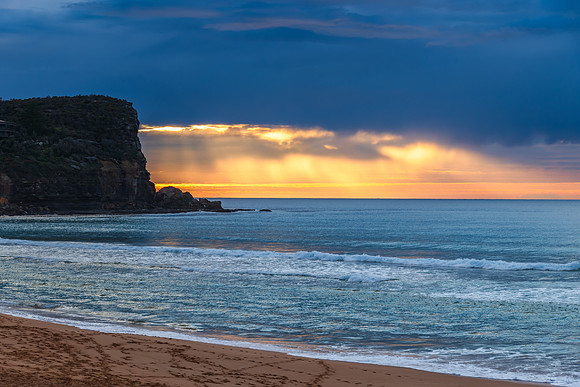 Winter sunrise by the sea shore with rain clouds