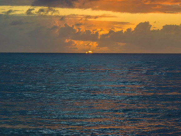 Moody seascape with sun rising on the horizon