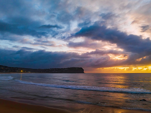 Drizzly moody sunrise seascape with cloud filled sky