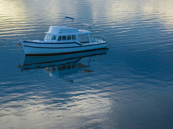 Aerial sunrise waterscape with boat and reflection