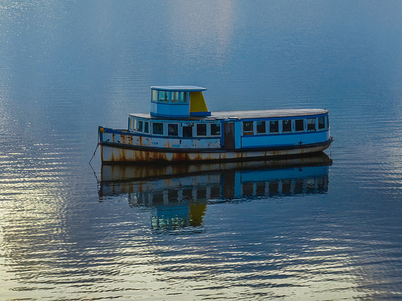 Aerial sunrise waterscape with boat and reflection