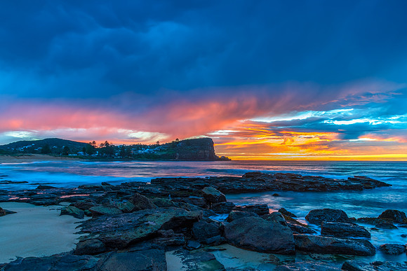 Winter sunrise by the sea shore with rain clouds