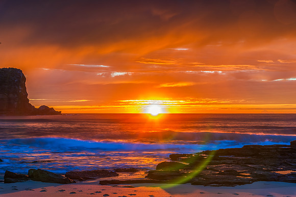 Winter sunrise by the sea shore with rain clouds