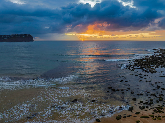 Drizzly moody sunrise seascape with cloud filled sky