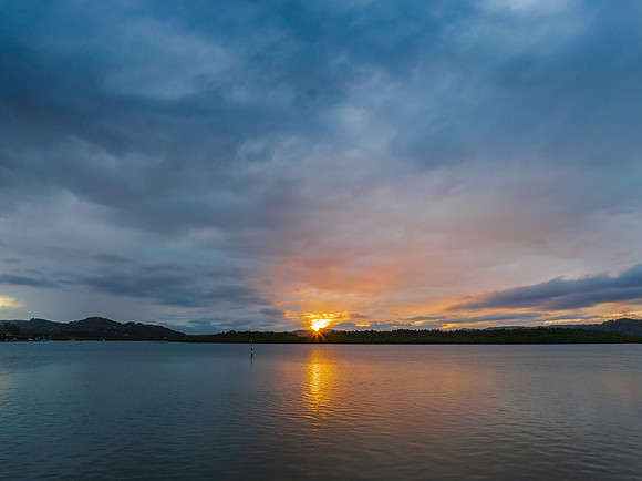The sun trying to burst through the rain clouds and shine over t